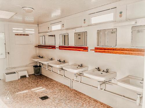 a bathroom with three sinks and two mirrors at Lodg'ing Nature Camp Presqu'île Crozon in Lanvéoc