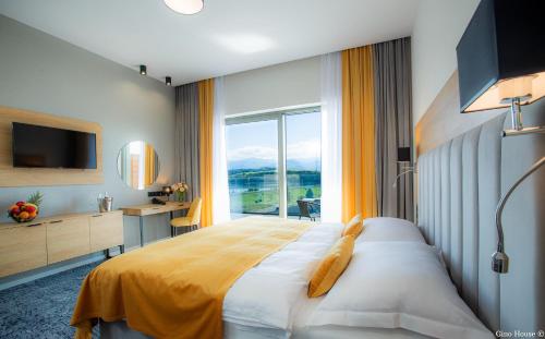 sypialnia z dużym łóżkiem i dużym oknem w obiekcie Bešeňová Gino Paradise Apartments with Aquapark w Beszeniowej