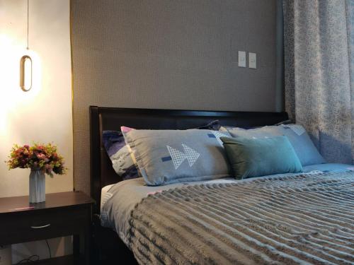 a bedroom with a bed with blue pillows on it at Elite Pod 1205 Knightsbridge Residences Makati in Manila