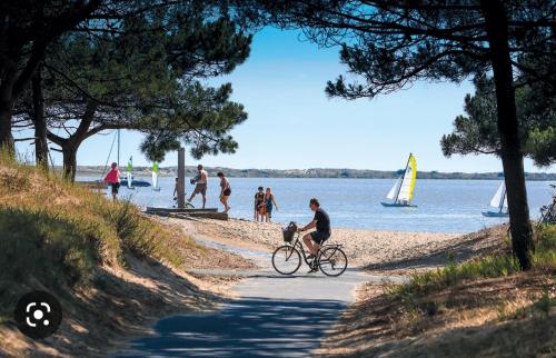 a man riding a bike on the beach at mobilhome 741 Les Charmettes in Les Mathes