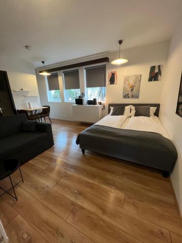 a bedroom with a large bed and a couch at Studio apartment in Hafnarfjordur in Hafnarfjörður