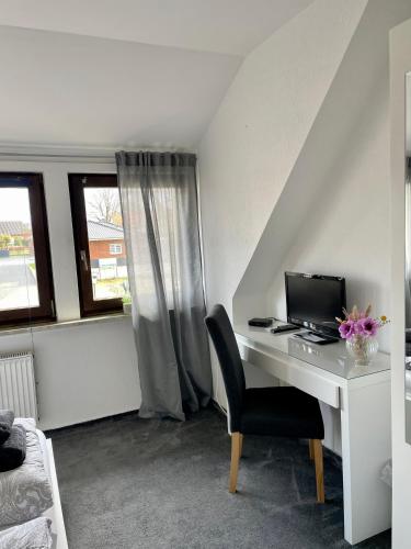 a desk with a computer and a chair in a room at Zum Deutschen Heinrich in Gifhorn