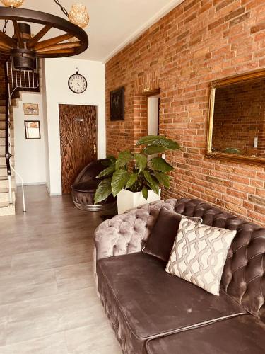 a living room with a couch and a brick wall at Zum Deutschen Heinrich in Gifhorn