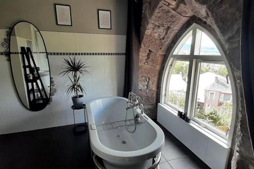 een badkamer met een wastafel, een bad en een raam bij The Viewpoint, 2 Bedroom Apartment in Crieff in Crieff