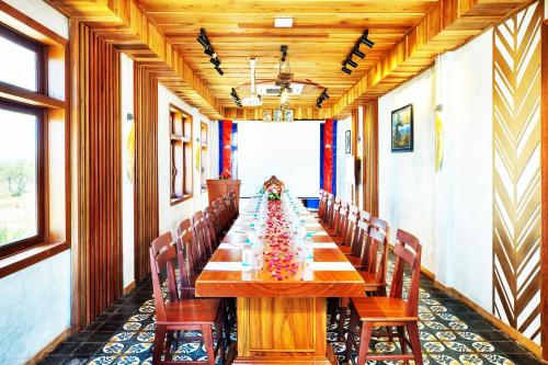 a long wooden table in a room with chairs at KNN Luxury Hill in Sen Monorom