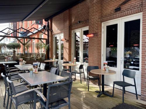 a restaurant with tables and chairs on a patio at Hotel Tholen in Tholen