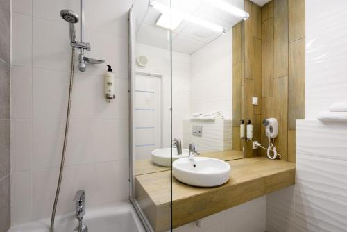 La salle de bains est pourvue d'un lavabo et d'une douche. dans l'établissement Apartment & Rooms at Wierzbiecice street, à Poznań