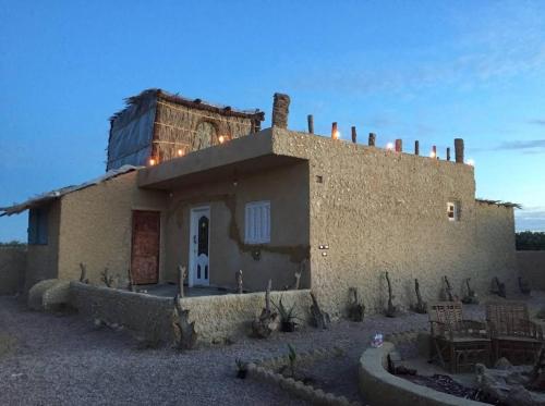 un piccolo edificio con un serbatoio sopra di Friendo's House & Hot Spring a Siwa