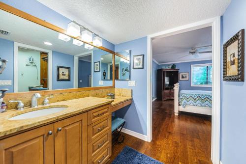 a bathroom with a sink and a mirror and a bedroom at La Concha 5 in Clearwater Beach