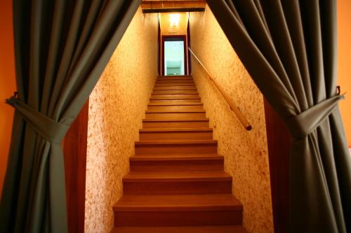 a stairway with blue curtains and stairs with a window at Villa Camurana in Medolla