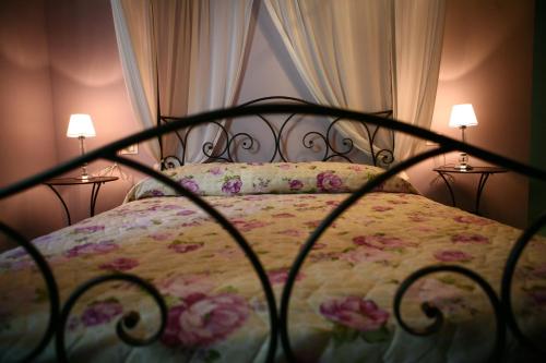 a bed with a floral bedspread and two lamps at Villa Camurana in Medolla