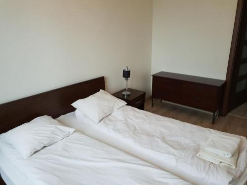 un letto con lenzuola e cuscini bianchi in una camera da letto di Apartment & Rooms at Strusia street a Poznań