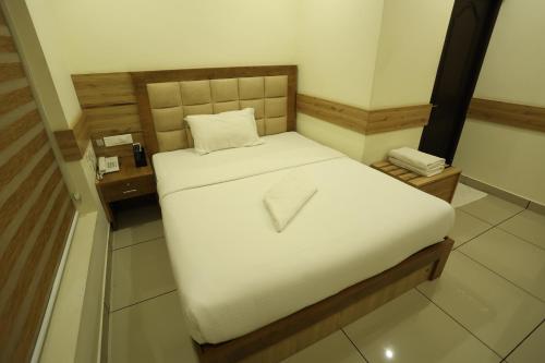a small bedroom with a white bed with at Balaji Regency Kanhangad in Kānnangād