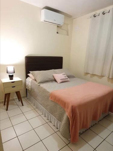 a small bedroom with a bed and a night stand at Apartamento TOP CLIMATIZADO em CRICIÚMA-SC - ótimo CUSTO-BENEFÍCIO - Cozinha completa - Cama Box - WiFI - Smart TV - Apps YouTube - NetFlix - Prime Vídeo - Garagem coberta - Portaria Digital 24h - Lugar sossegado e arborizado - Acomoda até 5 pessoas in Criciúma
