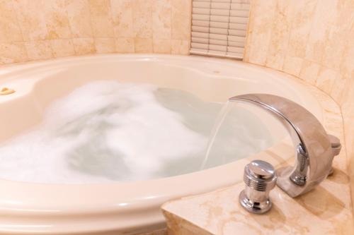 a bath tub with water pouring from a faucet at J&A Classic Hotel in Lima