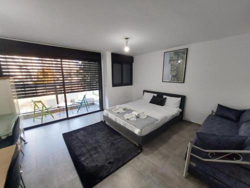 a bedroom with a bed and a blue couch at Lovely garden Flat in Tel Aviv in Tel Aviv