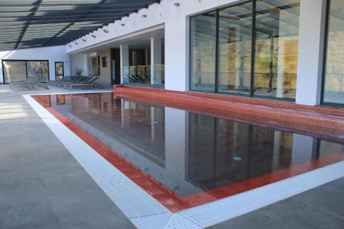 a swimming pool in the middle of a building at Eira do Serrado - Hotel & Spa in Curral das Freiras