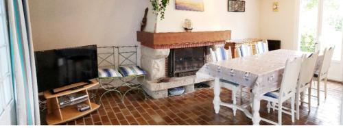 uma sala de estar com uma mesa e uma lareira em AU GRAND PIN em Fouesnant