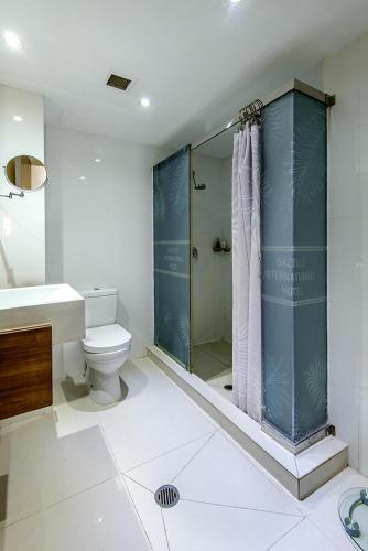 a bathroom with a shower and a toilet and a sink at Gazelle International Hotel in Kokopo