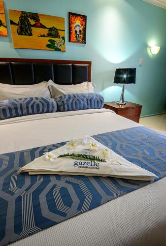 a hotel room with two beds with a towel on the bed at Gazelle International Hotel in Kokopo