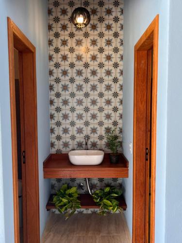 a bathroom with a sink on a table with a wall at Recanto da Roca in Domingos Martins