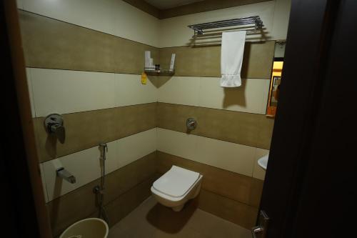 a bathroom with a toilet and a sink at Balaji Regency Kanhangad in Kānnangād