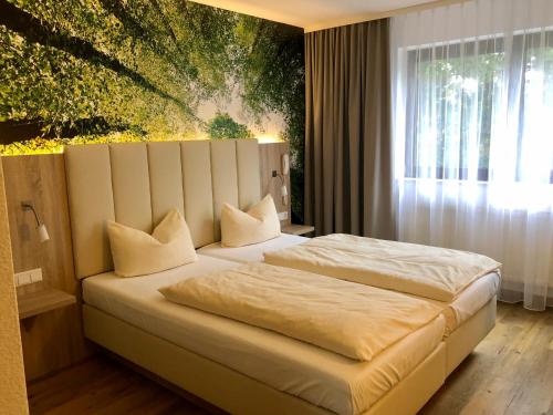 a bedroom with a bed with a painting on the wall at Hotel zur Kanone in Tautenhain