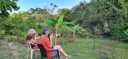 two people sitting in chairs taking a picture with a camera at Zirumake Hostel Dentro del Parque Tayrona in El Zaino