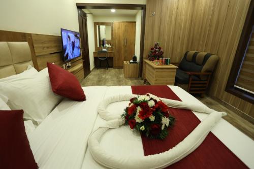 a hotel room with a bed with a flower arrangement on it at Balaji Regency Kanhangad in Kānnangād