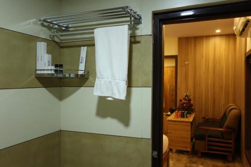 a bathroom with a towel hanging on a wall at Balaji Regency Kanhangad in Kānnangād