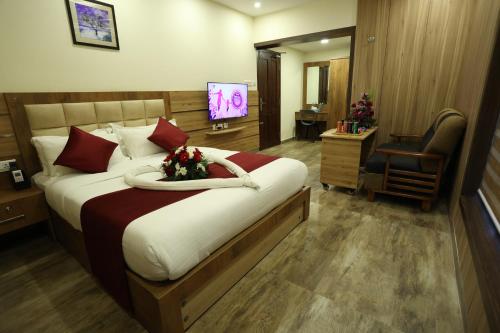 a bedroom with a large bed with flowers on it at Balaji Regency Kanhangad in Kānnangād
