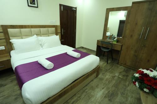 a hotel room with a large bed and a mirror at Balaji Regency Kanhangad in Kānnangād