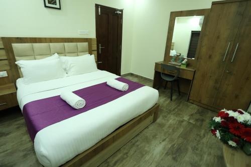 a hotel room with a large bed and a mirror at Balaji Regency Kanhangad in Kānnangād