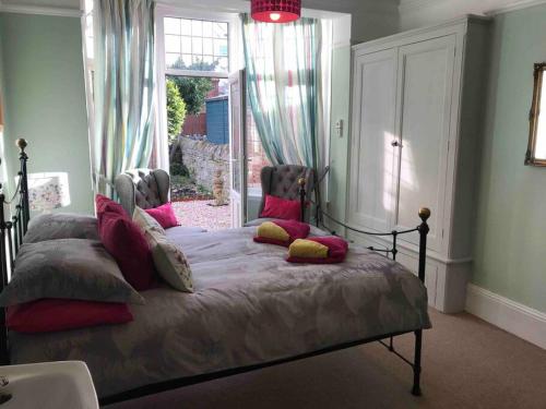 Un dormitorio con una cama con almohadas y una ventana. en Brook Lodge Garden Flat, en Swanage
