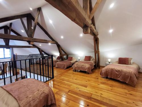 a attic room with three beds and wooden floors at Maison 12 personnes, Blesle in Blesle
