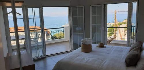 a bedroom with a bed and a view of the ocean at Villa Eleni Greece - wonderful sea view studios in Nea Roda