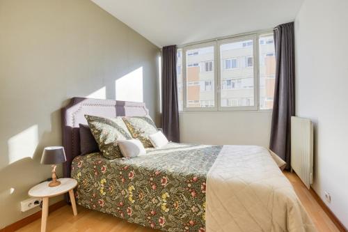 een slaapkamer met een bed en een raam bij 50m2 Cosy Parking Balcon in Longjumeau