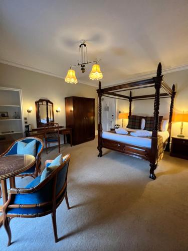 a bedroom with a bed and a table and chairs at Greshornish House Hotel in Edinbane
