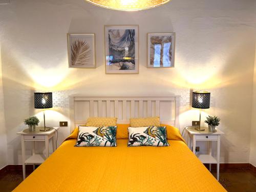 una camera da letto con un grande letto giallo con due lampade di Leaning Tower Suite a Pisa