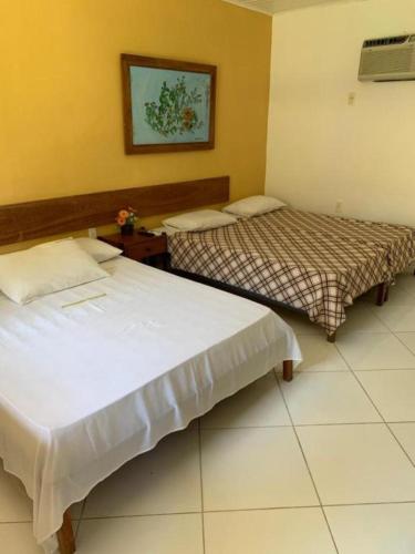 two beds in a hotel room with at Pousada Grauça in Cacha Pregos