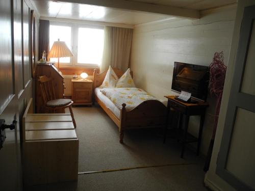 a small bedroom with a bed and a television at Landgasthaus Bären in Grub