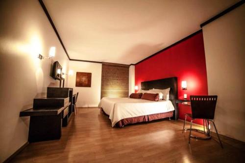 - une chambre avec un lit et un mur rouge dans l'établissement Hotel Inglaterra, à Tampico