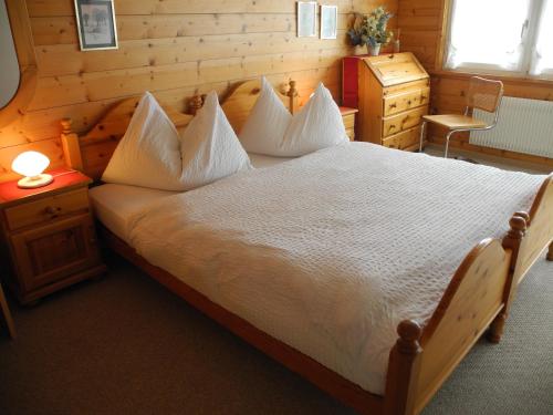 a bedroom with a large bed with white sheets and pillows at Landgasthaus Bären in Grub
