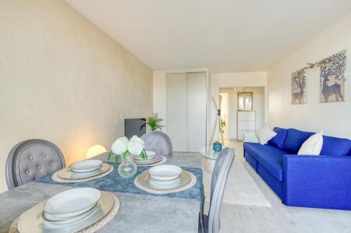 un salon avec un canapé bleu et une table dans l'établissement Escale de l'Yvette - 50m2 Cosy, Balcony & Parking, à Longjumeau
