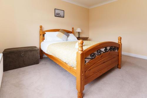 ein Schlafzimmer mit einem Holzbett in einem Zimmer in der Unterkunft OAKWOOD HOUSE Detached home in South Leeds in Leeds