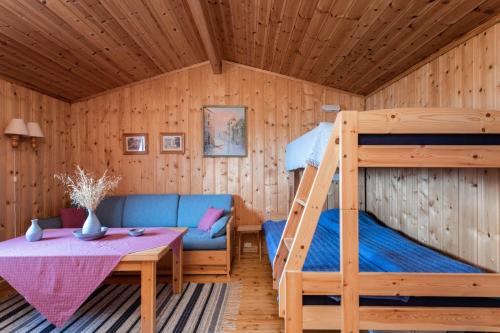 a bedroom with a bunk bed and a couch at Fantastisk sjøhytte, 10 sengeplasser, strand og egen brygge in Fredrikstad