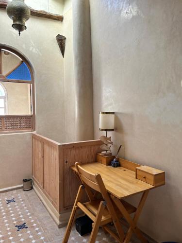 a wooden desk in a room with a window at Riad Les Sables Bleus, médina, lumineux et terrasse privée sur mer in Essaouira