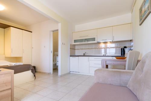 a kitchen and living room with a couch and a table at Apartments Stare Brajde in Lopar