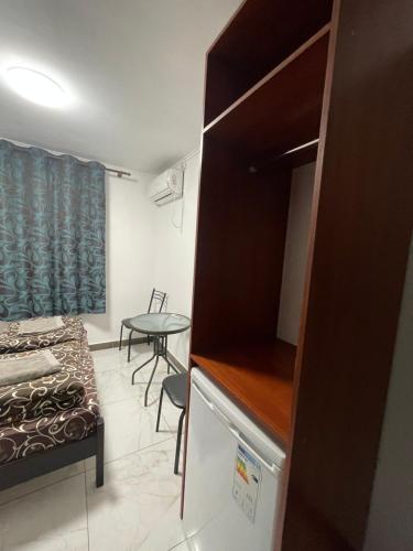 a small room with a bed and a table at Shaarei Zion in Umanʼ