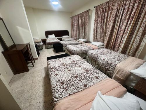 a room with several beds in a room at Student House in Madaba